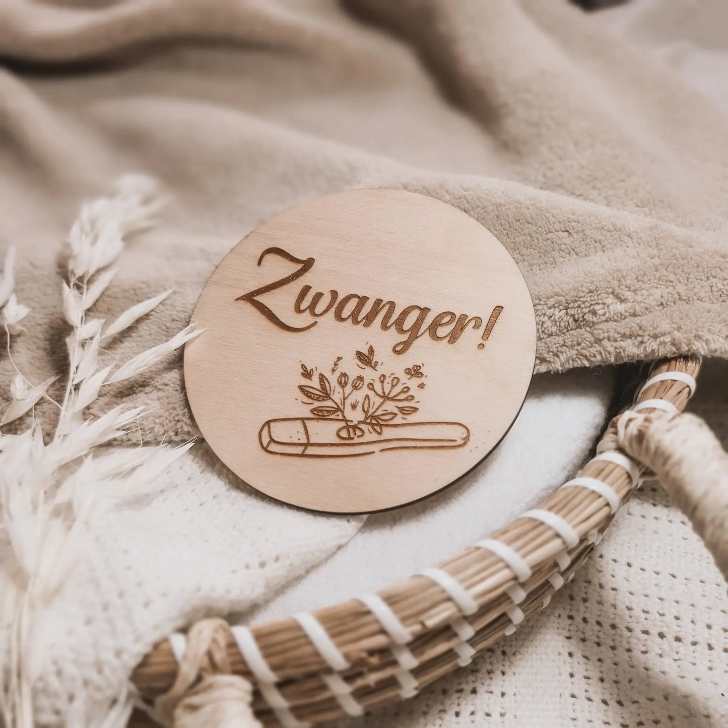 Houten aankondigingsbordje voor een zwangerschap, gegraveerd met de tekst "zwanger" en een zwangerschapstest waar plantjes uit groeien.