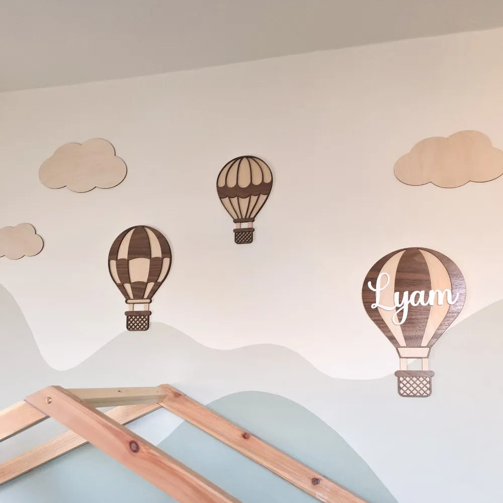 Gepersonaliseerde houten muurdecoratie set van luchtballonnen en wolkjes in een kinderkamer.
