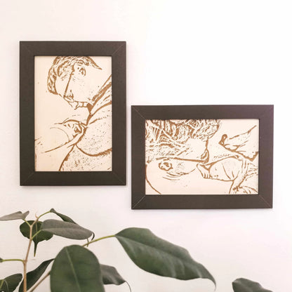 Twee foto's op hout gegraveerd van een vader met pasgeboren zoon in een donkere omlijsting.