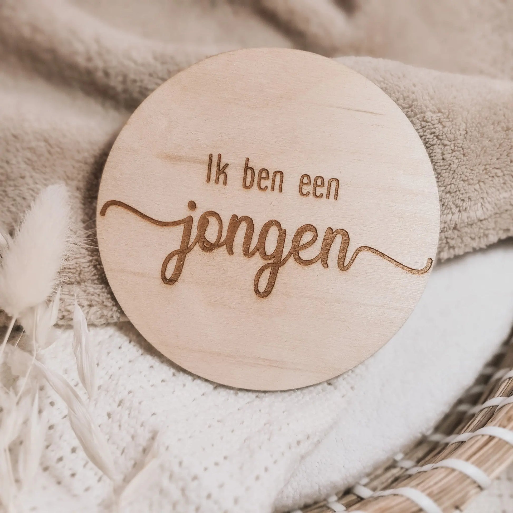 Houten aankondigingsbordje, gegraveerd met de tekst "Ik ben een jongen".