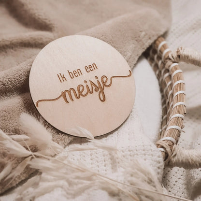 Houten aankondigingsbordje, gegraveerd met de tekst "Ik ben een meisje".