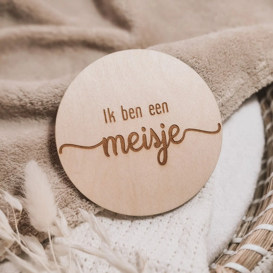 Houten aankondigingsbordje, gegraveerd met de tekst "Ik ben een meisje".