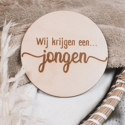 Houten aankondigingsbordje, gegraveerd met de tekst "Wij krijgen een jongen".