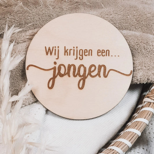 Houten aankondigingsbordje, gegraveerd met de tekst "Wij krijgen een jongen".