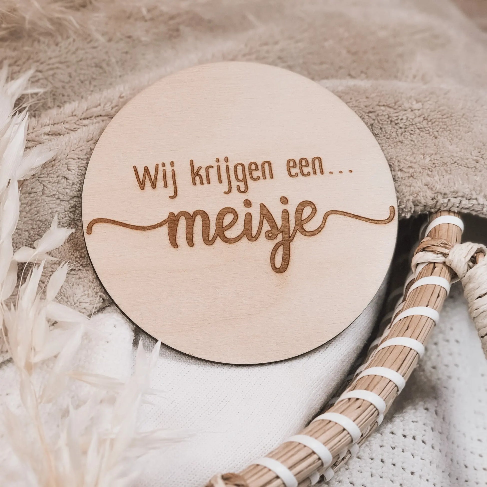 Houten aankondigingsbordje, gegraveerd met de tekst "Wij krijgen een meisje".