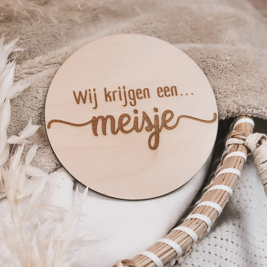 Houten aankondigingsbordje, gegraveerd met de tekst "Wij krijgen een meisje".
