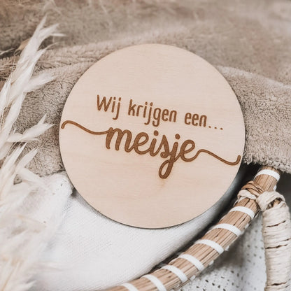 Houten aankondigingsbordje, gegraveerd met de tekst "Wij krijgen een meisje".