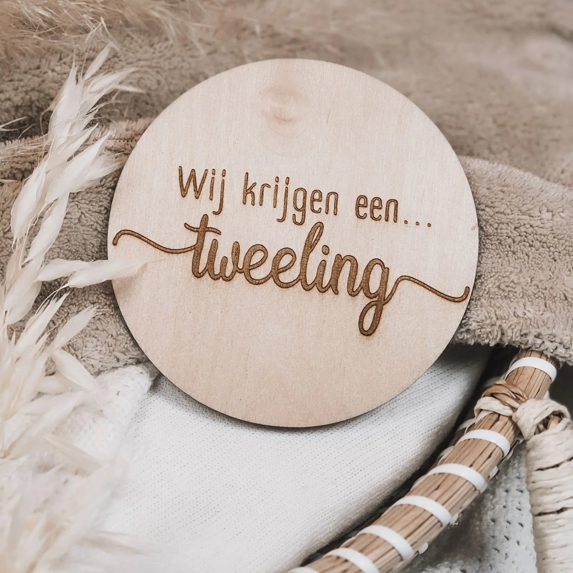 Houten aankondigingsbordje, gegraveerd met de tekst "Wij krijgen een tweeling".