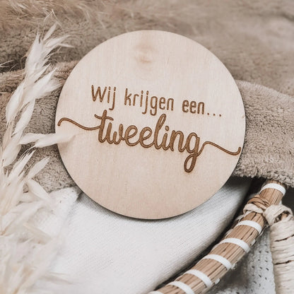 Houten aankondigingsbordje, gegraveerd met de tekst "Wij krijgen een tweeling".