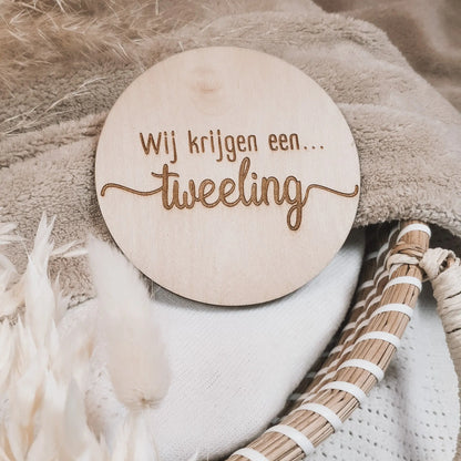Houten aankondigingsbordje, gegraveerd met de tekst "Wij krijgen een tweeling".