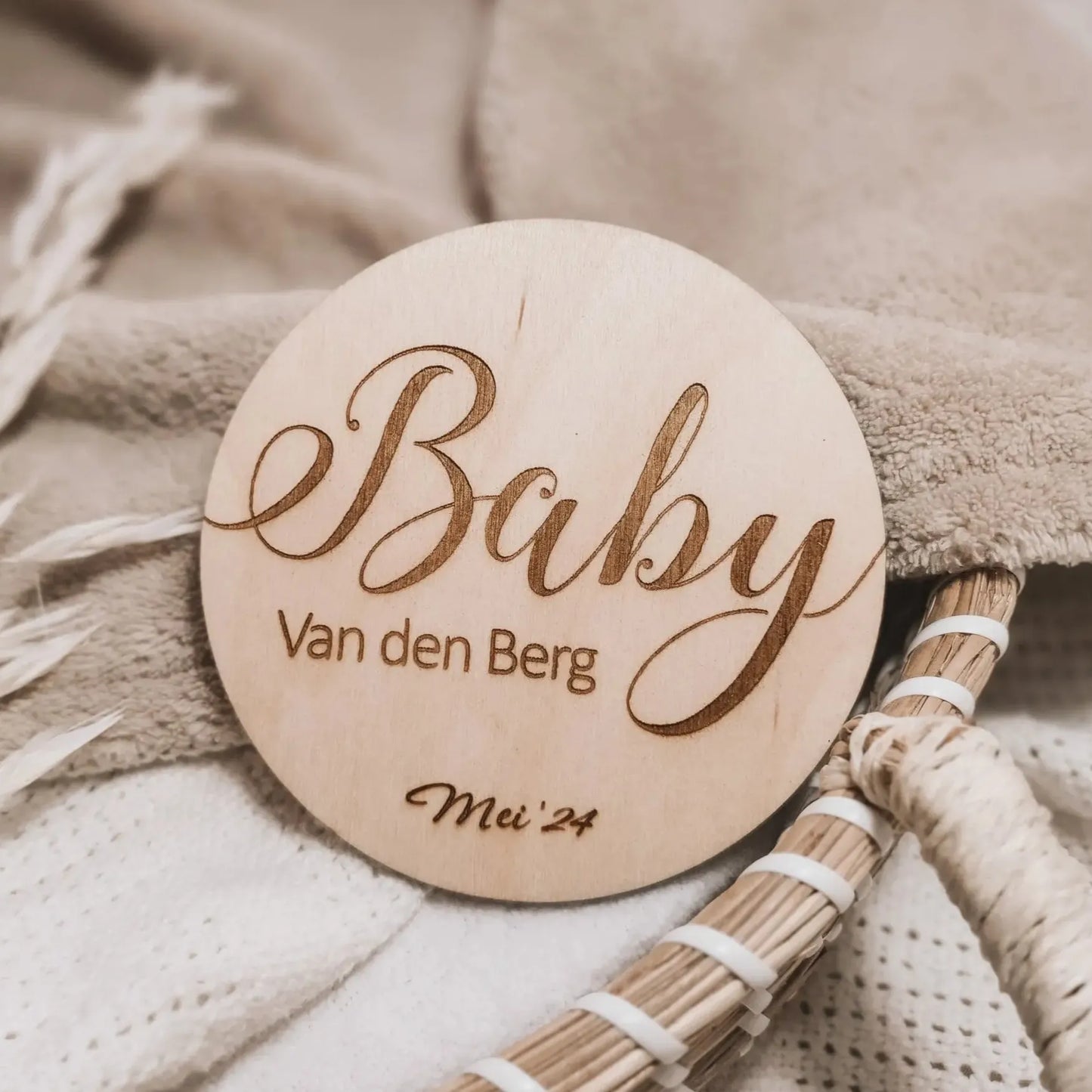 Houten aankondigingsbordje voor een zwangerschap, gegraveerd met de achternaam en uitgerekende datum.