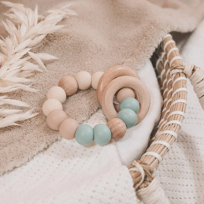 Siliconen bijtring in beige en blauw met houten ringen en kralen.