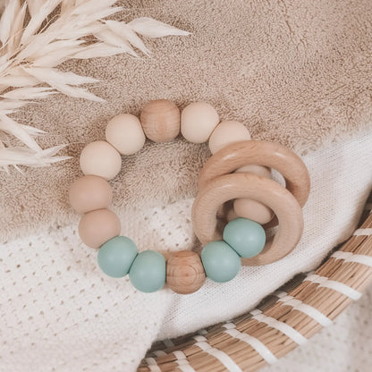 Siliconen bijtring in beige en blauw met houten ringen en kralen.