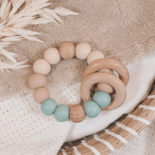 Siliconen bijtring in beige en blauw met houten ringen en kralen.