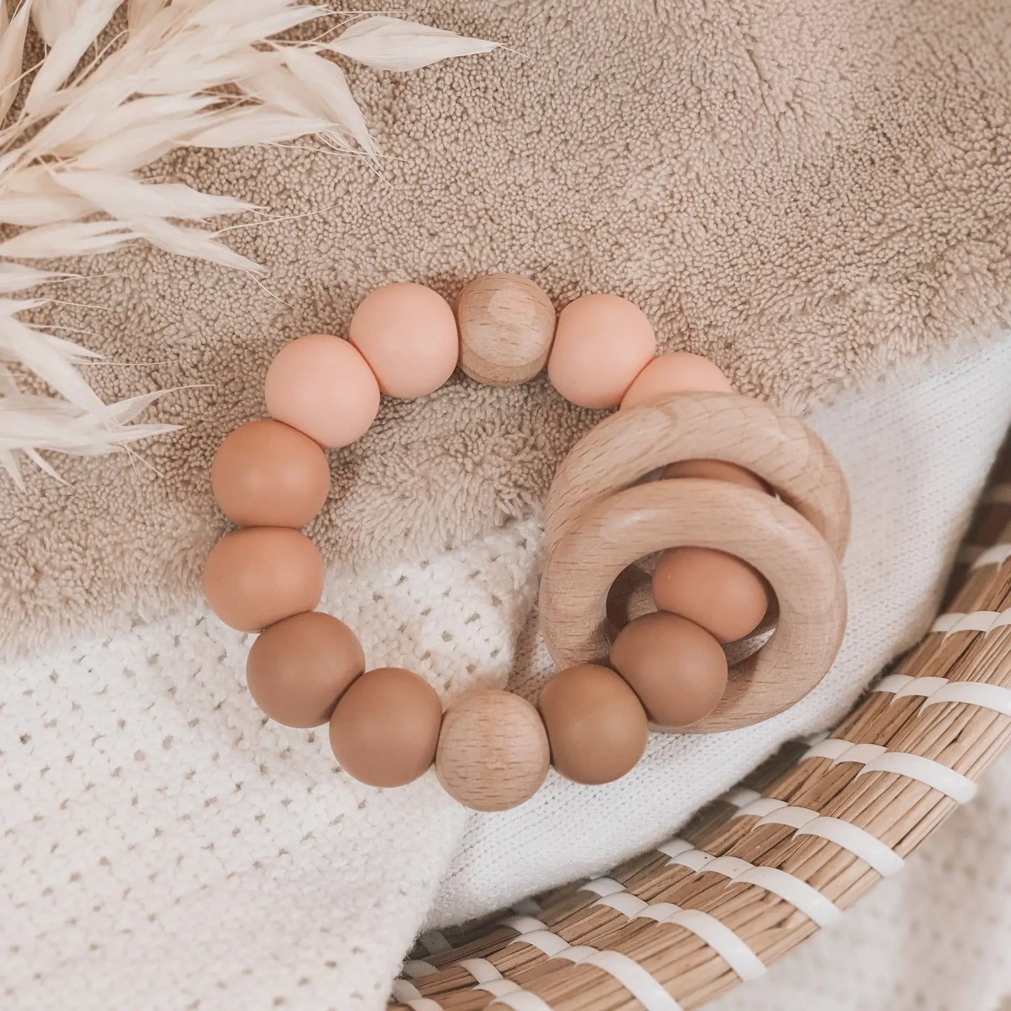 Siliconen bijtring in zalmkleur en ombre effect met houten ringen en kralen.