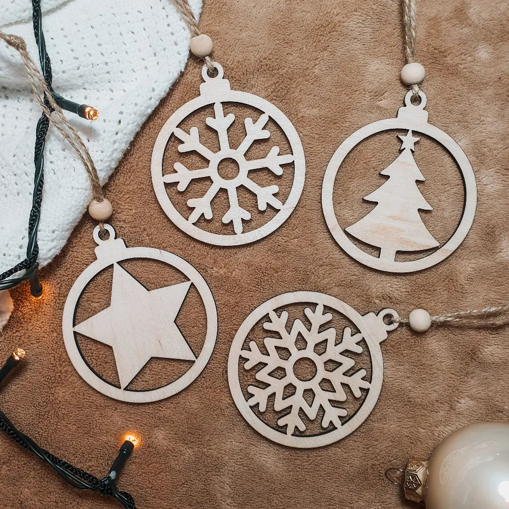 Set van vier houten kerstballen met uitgesneden sneeuwvlokjes, ster en kerstboom.