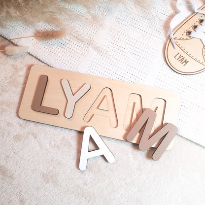 Gepersonaliseerde houten naampuzzel met pastelgekleurde letters, voorbeeld met de naam Lyam.