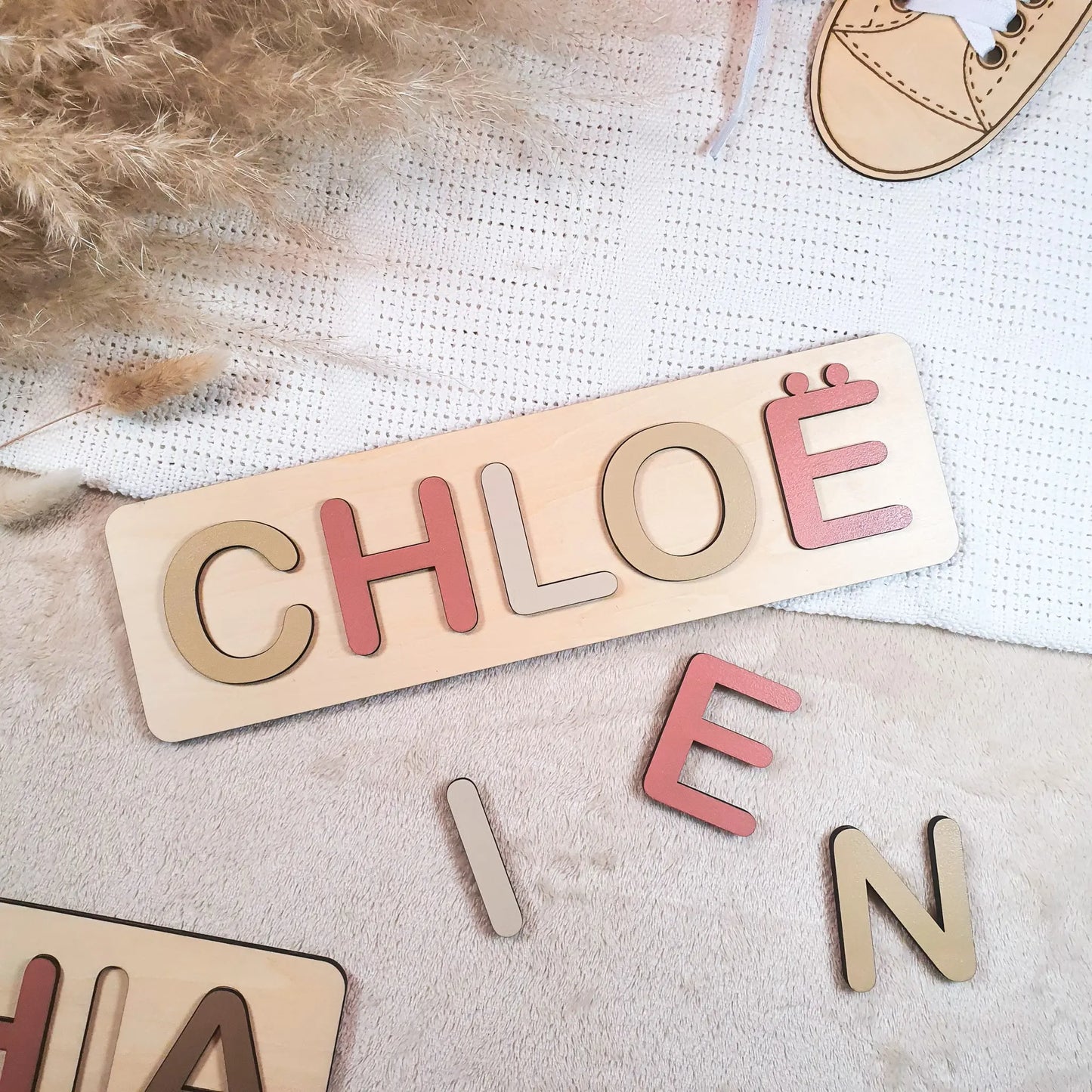 Gepersonaliseerde houten naampuzzel met pastelgekleurde letters, voorbeeld met de naam Chloë.