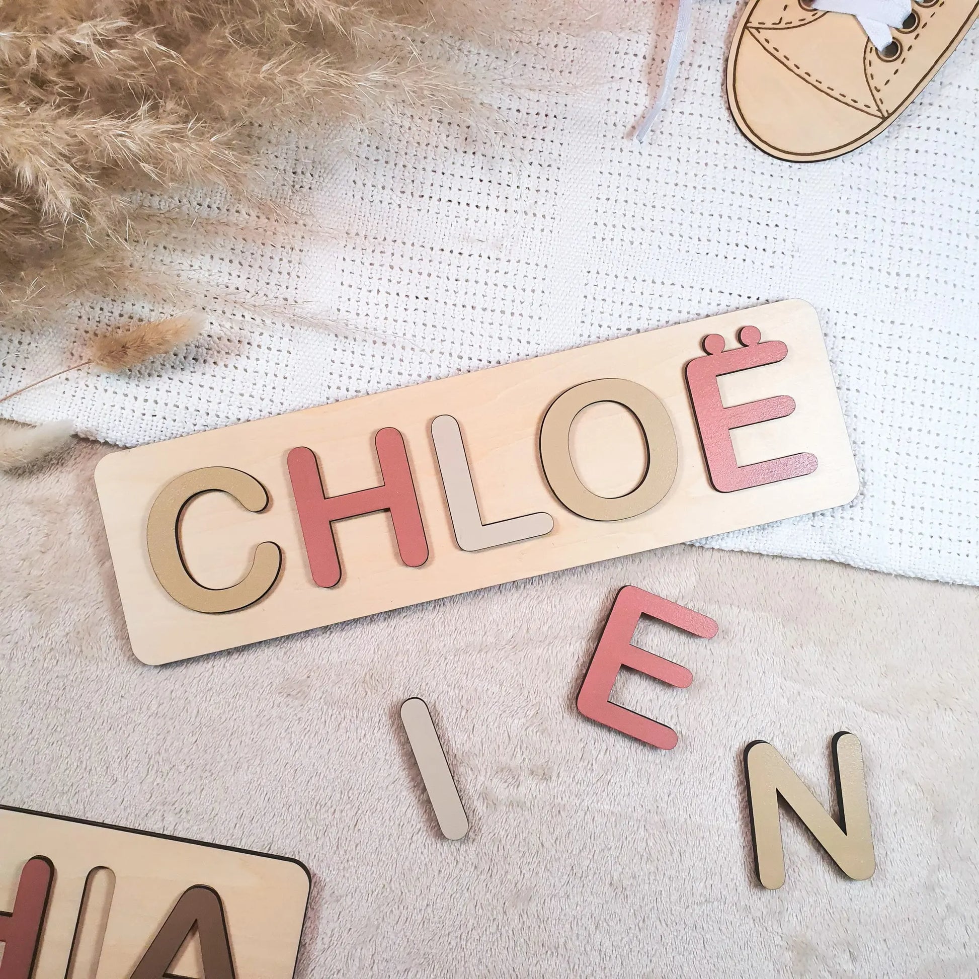 Gepersonaliseerde houten naampuzzel met pastelgekleurde letters, voorbeeld met de naam Chloë.