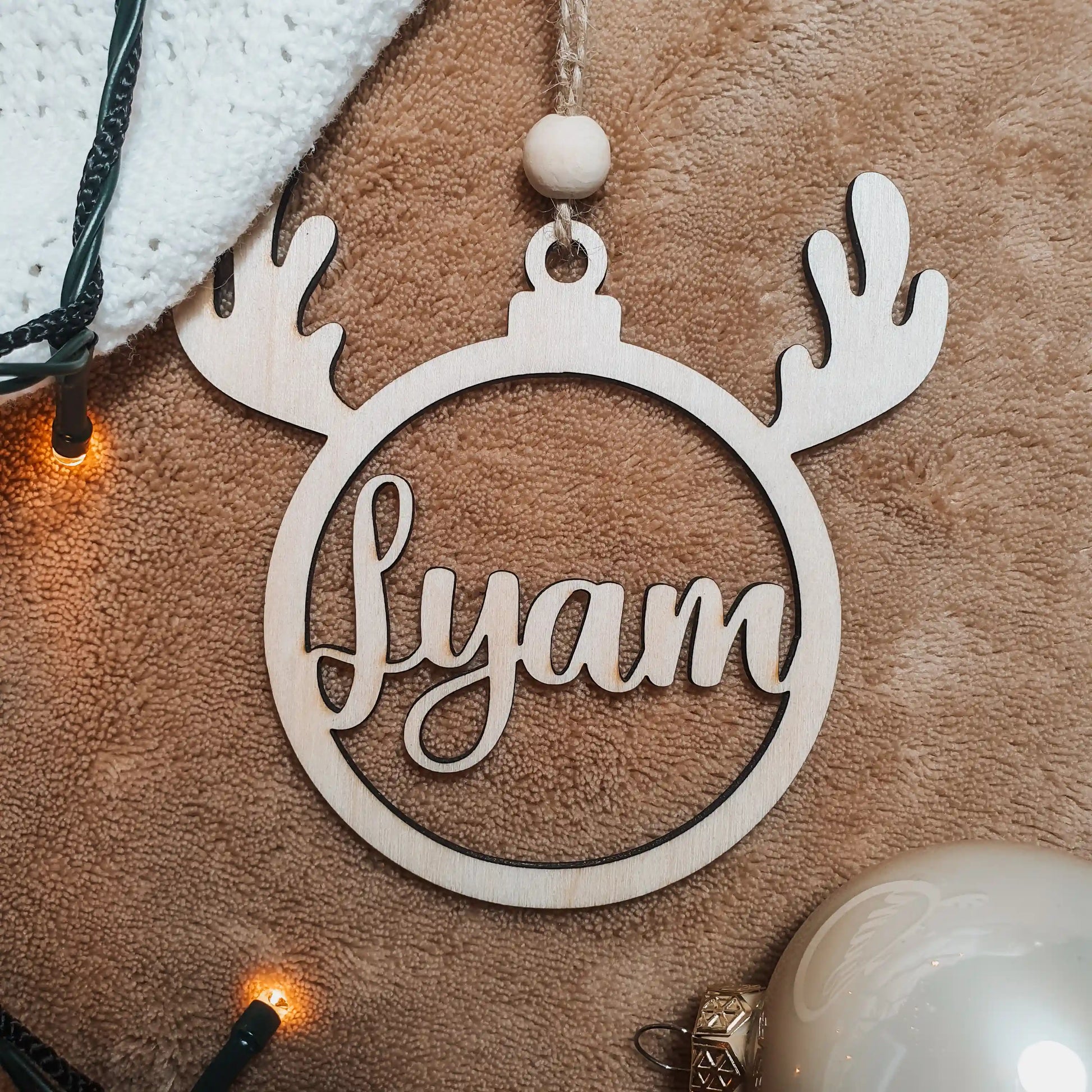 Houten kerstbal met rendiergewei en uitgesneden naam "Lyam".