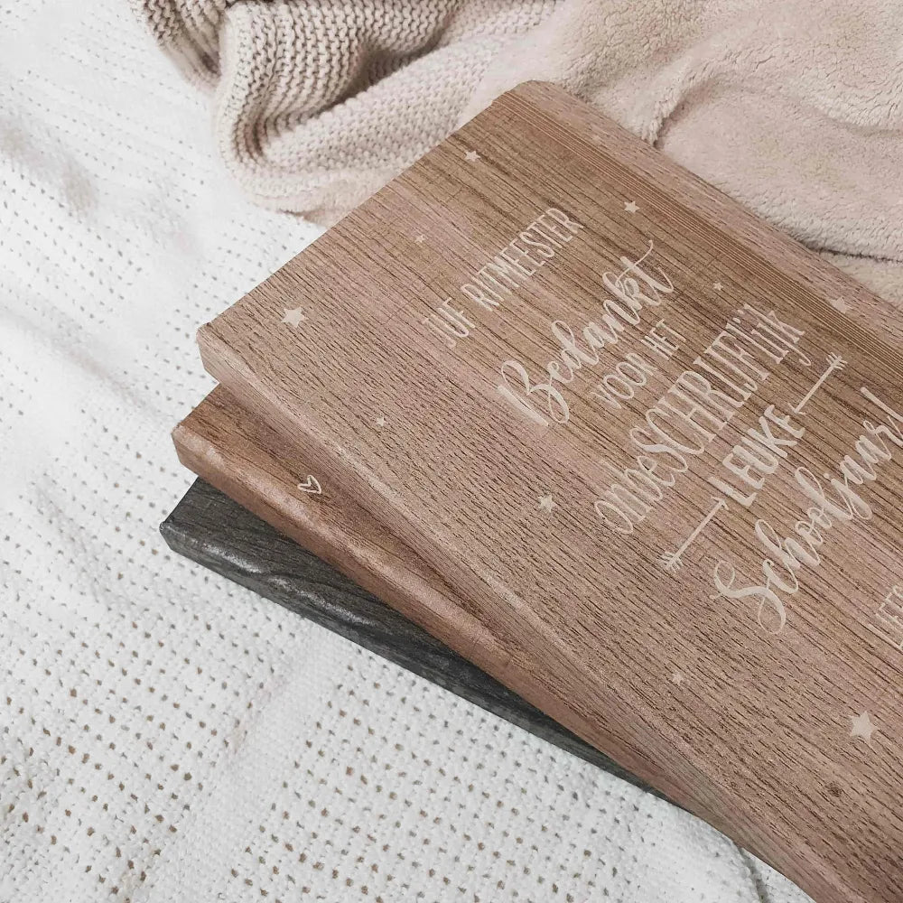 Gegraveerde notitieboekjes in verschillende kleuren houtlook voor meesters en juffen met de tekst 'Bedankt voor het onbeschrijflijk leuke schooljaar'.