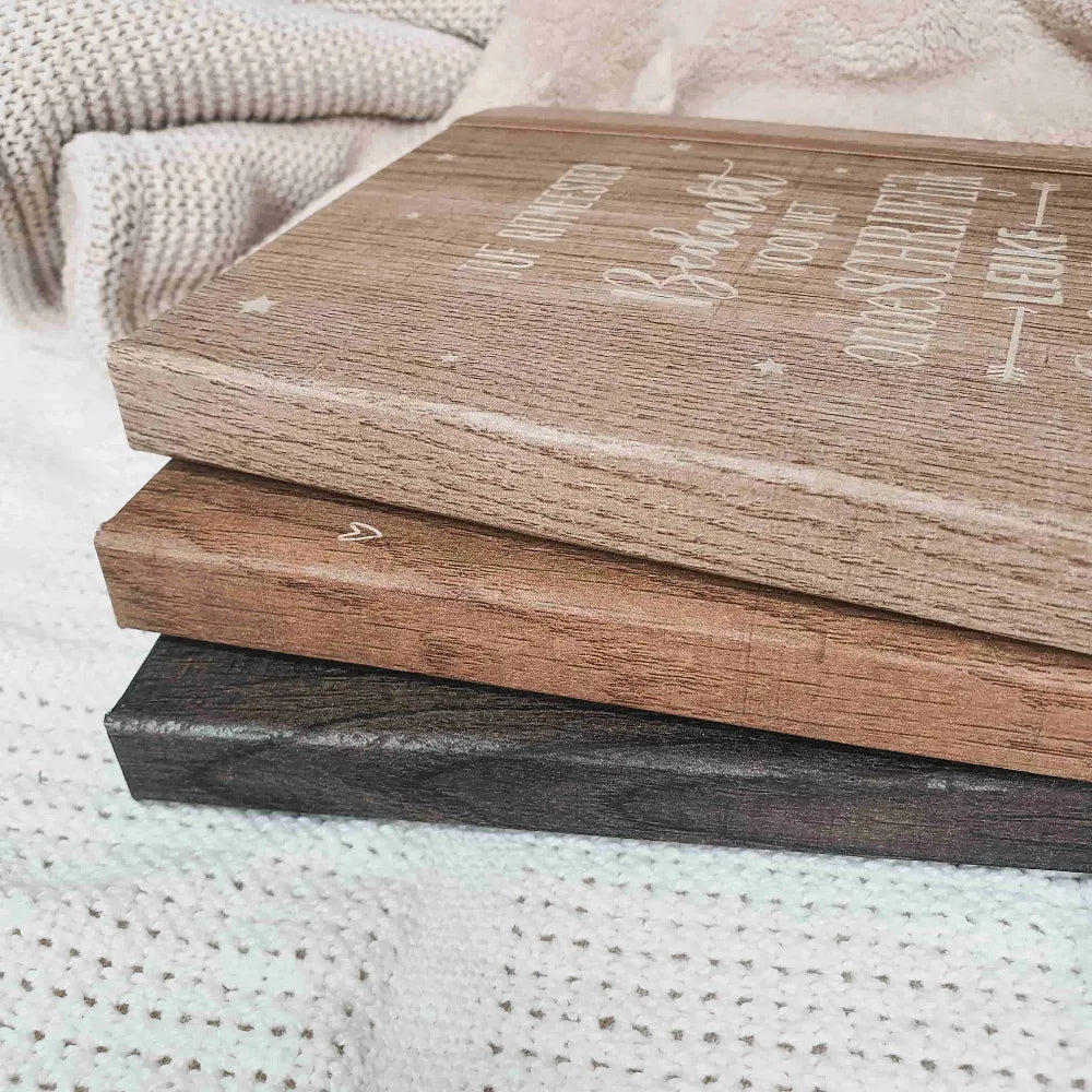 Gegraveerde notitieboekjes in verschillende kleuren houtlook voor meesters en juffen met de tekst 'Bedankt voor het onbeschrijflijk leuke schooljaar'.