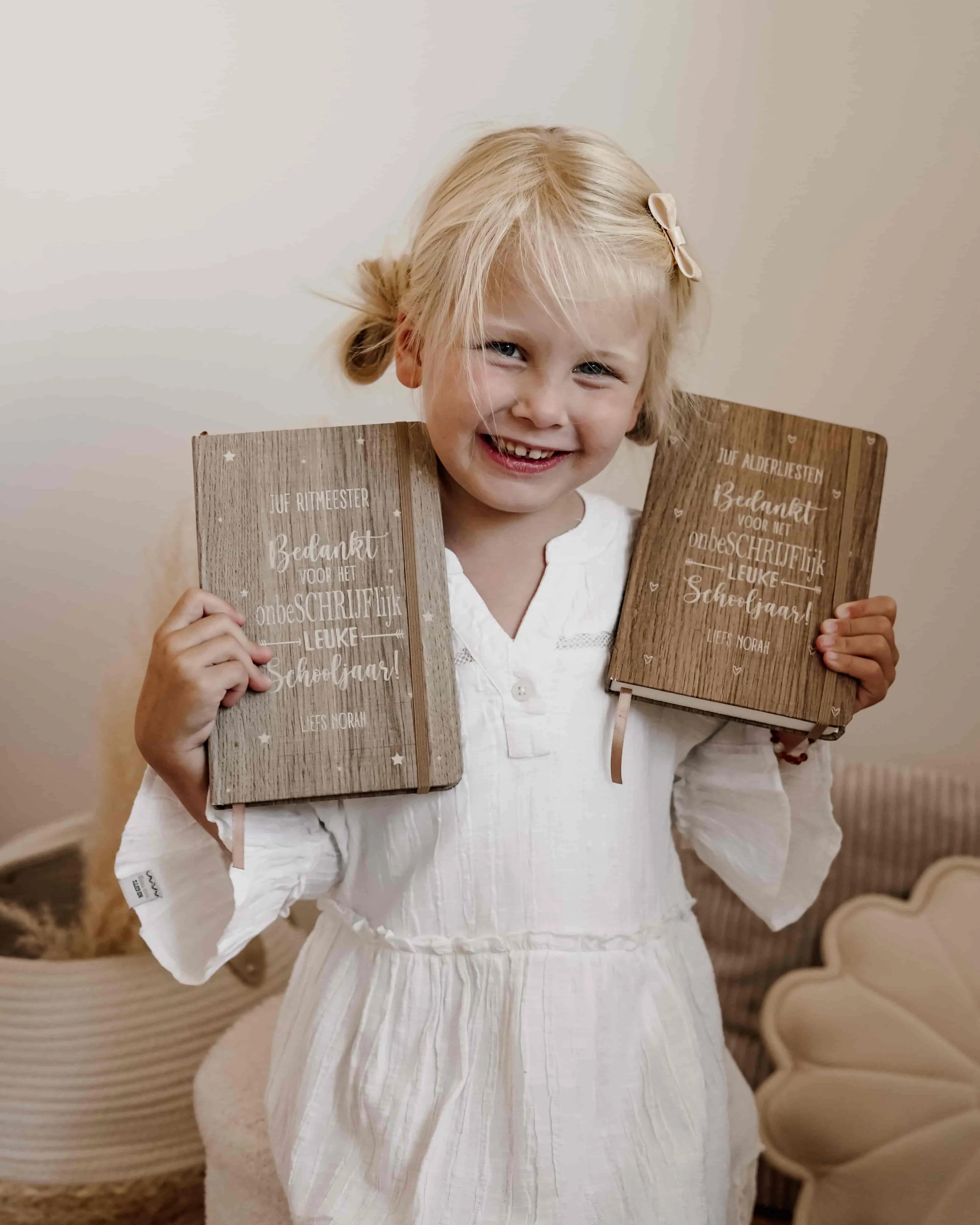 Jong meisje dat poseert met gepersonaliseerde notitieboekjes voor haar juffen.
