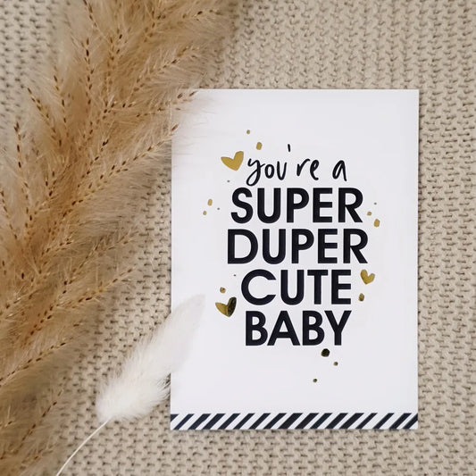 Gender neutraal wit kaartje met zwarte en gouden opdruk voor een geboorte met de tekst 'You're a super duper cute baby'.