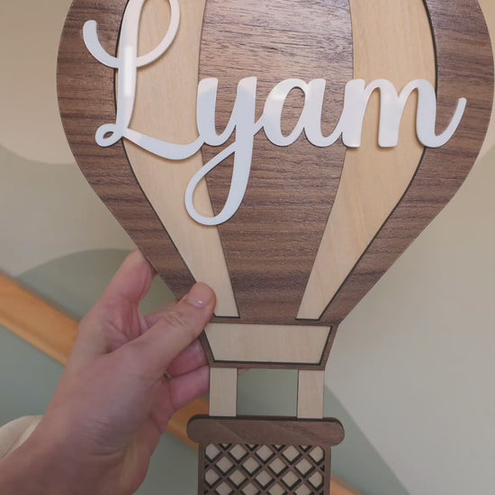 Gepersonaliseerde houten muurdecoratie set van luchtballonnen en wolkjes in een kinderkamer.
