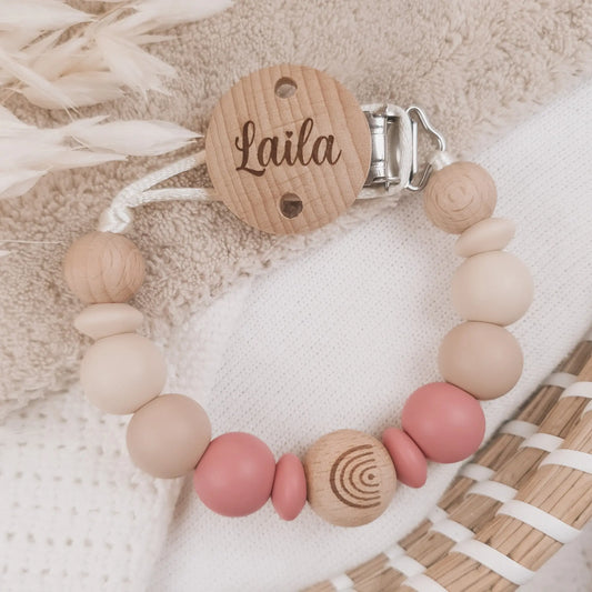 Gepersonaliseerd speenkoord met naam gegraveerd op de clip en siliconen kralen in beige en roze met houten details.
