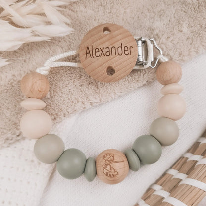 Gepersonaliseerd speenkoord met naam gegraveerd op de clip en siliconen kralen in beige en groen met houten details.