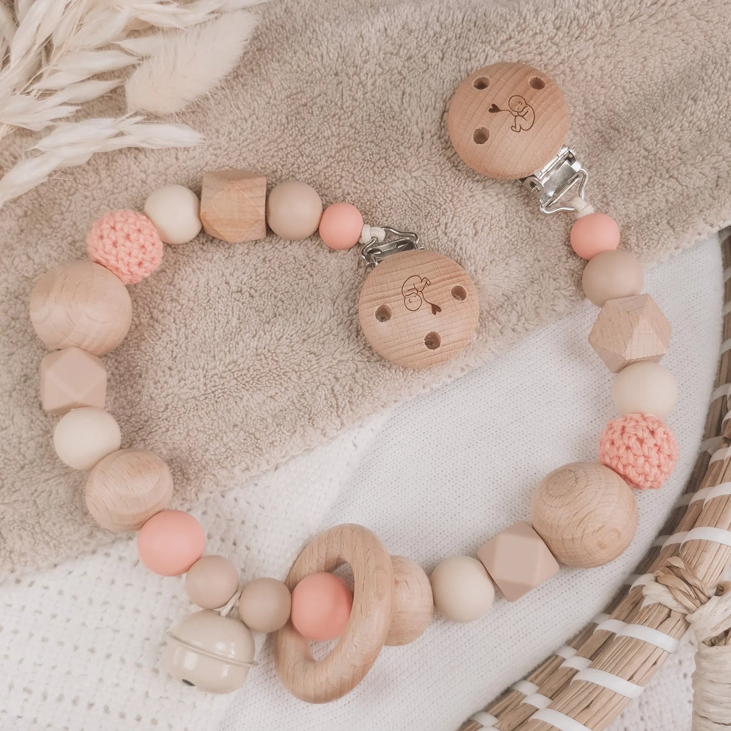 Wagenspanner in beige en zalmkleur met siliconen en houten kralen.