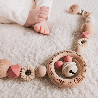 Babyvoetjes met een gepersonaliseerde roze wagenspanner, met hartjes, takjes en naam gegraveerd op de houten clip.